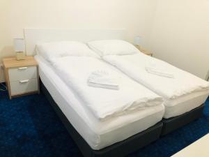 新扎姆基Penzión Pohoda的一张配有白色床单和枕头的大床
