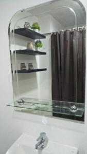 大雅台La Suerte Condo at SMDC Tagaytay的浴室镜子、水槽和浴帘