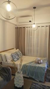 大雅台La Suerte Condo at SMDC Tagaytay的一间卧室配有一张床、一张桌子和灯