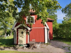 斯德哥尔摩Riddersviks Herrgård的前面有长凳的红色棚子