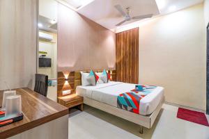 孟买FabHotel Grand Heritage Kurla West的一间卧室配有一张床和一张书桌