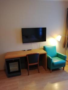 希尔科内斯Kirkenes Hotell的客房设有书桌、椅子和电视。