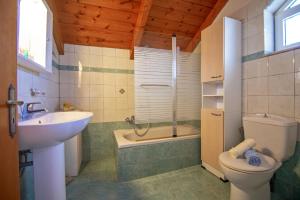 阿莫迪普萨罗一室公寓酒店的浴室配有盥洗盆、卫生间和浴缸。