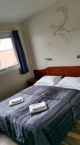 希尔科内斯Kirkenes Hotell的一间卧室配有一张床,上面有两条毛巾
