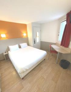 马蒂格Première Classe Martigues的卧室配有一张白色大床和一张书桌
