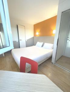 马蒂格Première Classe Martigues的酒店客房,设有两张床和一张红色椅子