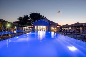 莱帕拉莱Palm Park Hotel的一座带椅子的大型蓝色游泳池和一座建筑