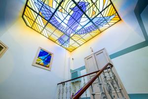 里加Blue Bird Hostel in Riga Old Town的楼梯天花板上的彩色玻璃窗