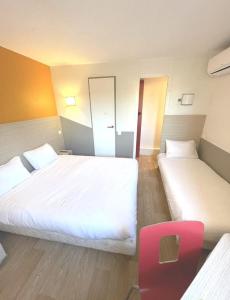 马蒂格Première Classe Martigues的酒店客房,设有两张床和一张红色椅子