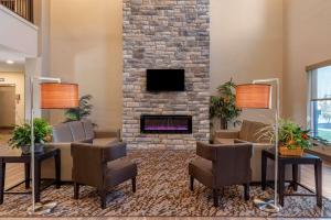 OdonMainStay Suites Newberry - Crane的大堂设有壁炉和桌椅。