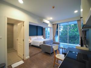 慕斯Fortune Courtyard Khao Yai Hotel Official的酒店客房带一张床、一张桌子和椅子