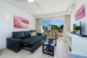 阿尔库迪亚港Apartamento Villa Cancun的客厅配有黑色沙发和电视