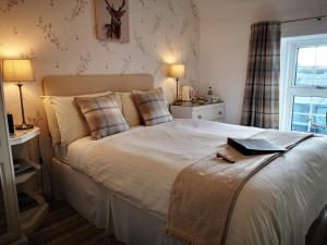 洛西茅斯Lossiemouth House的卧室设有一张白色大床和一扇窗户。