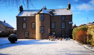 洛西茅斯Lossiemouth House的一座大砖砌的建筑,地面上积雪