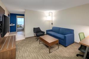 恩菲尔德Holiday Inn Express & Suites Halifax Airport, an IHG Hotel的客厅配有蓝色的沙发和桌子