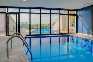 圣保罗蓝树维波迪维努顶级酒店的一个带玻璃窗的大型游泳池和一个大型游泳池