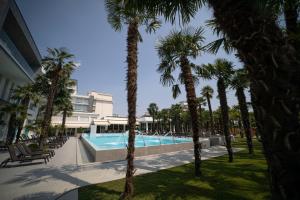 阿巴诺泰尔梅威尼斯温泉酒店的一座楼前棕榈树游泳池