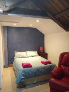 锡廷伯恩Watercress Barns的一间卧室配有一张带两个红色枕头的床