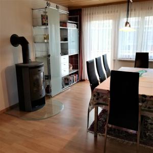 卢斯特瑙Ferienhaus Hämmerle´s的客厅配有桌子和燃木炉。