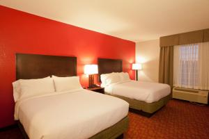Yampertown戈恩假日酒店的酒店客房,设有两张床和红色的墙壁
