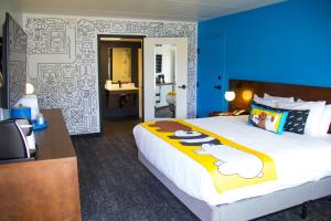 兰开斯特Cartoon Network Hotel的酒店客房设有一张大床和蓝色的墙壁。