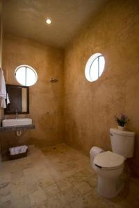 巴利亚多利德Hotel Boutique SAYAB的一间带卫生间和水槽的浴室以及两个窗户。