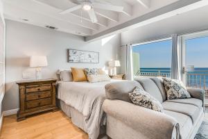 彭萨科拉海滩Big O Beach - White Sands Townhomes的一间卧室配有一张床、一张沙发和一个窗口