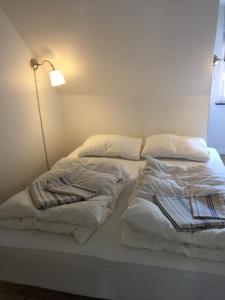 纳克斯考Nakskov Overnatning的一张带白色床单和枕头的床