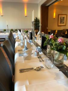 博特罗普王尔德街酒店-餐厅的一张长桌,上面有盘子和餐巾