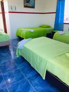 比亚米尔港卡米内特旅馆的一间设有三张床的客房,配有绿色的盖子