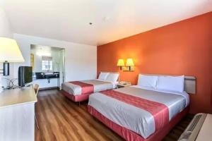 卡斯特罗维尔Coastal Valley Inn的酒店客房设有两张床和橙色的墙壁。