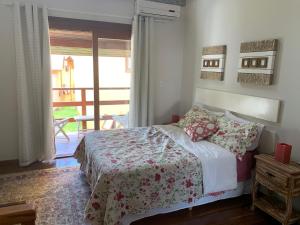 佩尼多Chalé aconchegante para família no Centro的一间卧室设有一张床,并有通往阳台的门