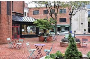 纽黑文New Haven Stays的建筑前方带桌椅的砖砌庭院