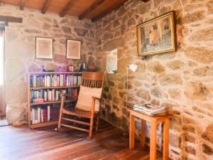 CastillónBelvilla by OYO Casa Ribeira Sacra的一间带椅子和书架的房间