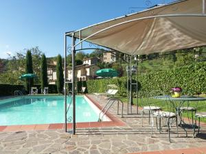普拉托韦基奥Belvilla by OYO Villa Lonanno的一个带桌子和遮阳伞的游泳池