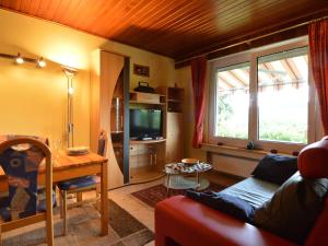 Boevange-ClervauxCozy Holiday Home in Boevange Clervaux with Garden的带沙发、桌子和电视的客厅