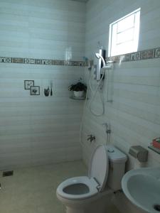 槟知HÒANG HÔN HOMESTAY的一间带卫生间、水槽和窗户的浴室