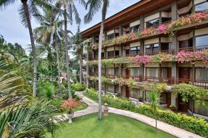 圣吉吉龙目岛嘉雅卡塔酒店的享有酒店外景,酒店外有鲜花和棕榈树