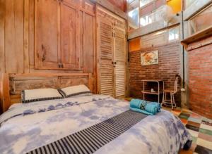 班图尔Lorong Homestay的一间卧室设有一张大床和砖墙