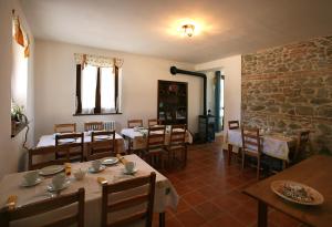 蒙特格里多尔福芬尼斯住宿加早餐旅馆的一间带桌椅和石墙的餐厅