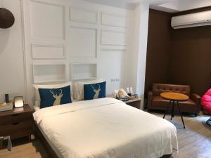 台东乐气球民宿的一间卧室配有白色床和蓝色枕头