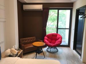 台东乐气球民宿的一间卧室配有红色椅子、桌子和窗户