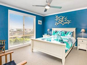 日落大道Blue Jetty的一间蓝色的卧室,配有白色的床和窗户