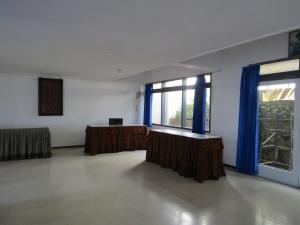 萨兰甘Hotel Pantes的一间空房间,配有蓝色窗帘和大窗户