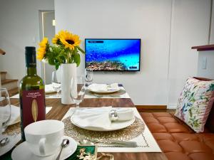 北谷町Sunset Beach House的一张桌子、一瓶葡萄酒和墙上的电视