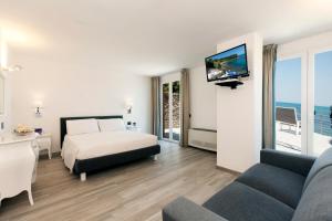 圣托斯特凡诺港多米希亚别墅酒店的酒店客房,配有床和沙发