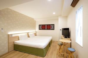 札幌唐草酒店札幌的一间卧室配有一张床、一台电视和一张桌子