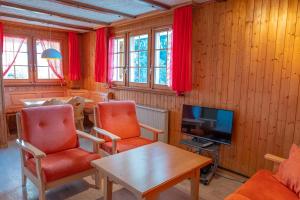 RosswaldChalet Allegra的客厅配有红色椅子和电视