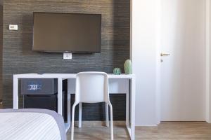 巴里波斯顿酒店的一间设有一张桌子的房间,墙上有一台电视机