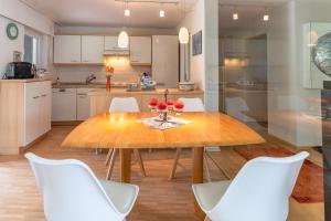 阿尔高内的伊门施塔特Haus Alpsee的厨房配有木桌和白色椅子